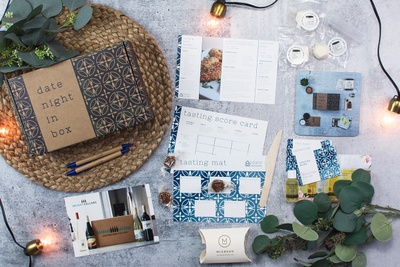 A Date Night in a Box with informational cards, tasting score cards, pens, and tasting mat.