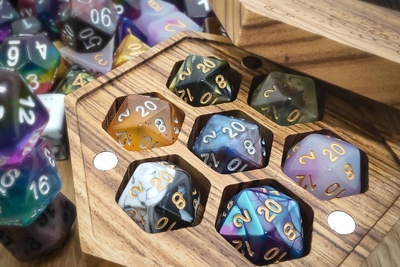 A wooden box filled with Dungeons and Dragons die from the D20 Collective subscription box.