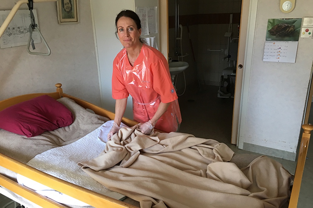 Titti Norling bäddar en säng på äldreboendet.
