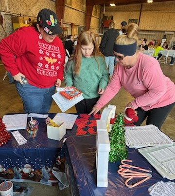 3 people look at activity on table