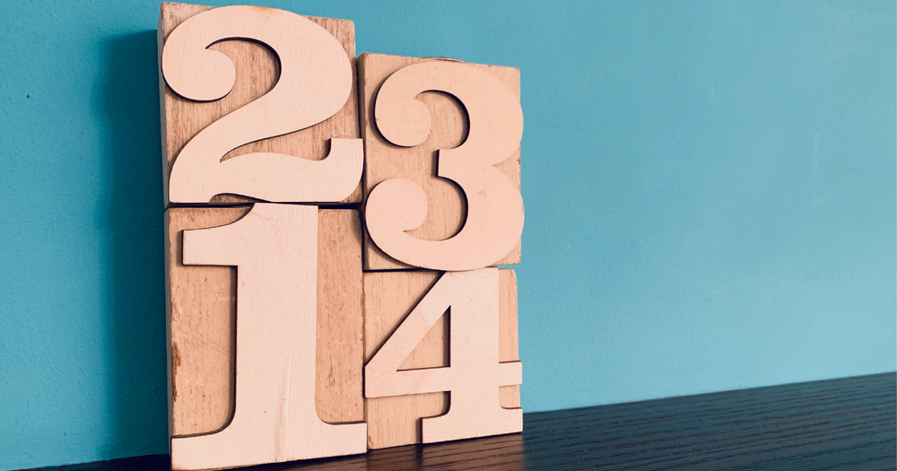 The numbers 1, 2, 3 and 4 inh wooden boxes against a blue background.