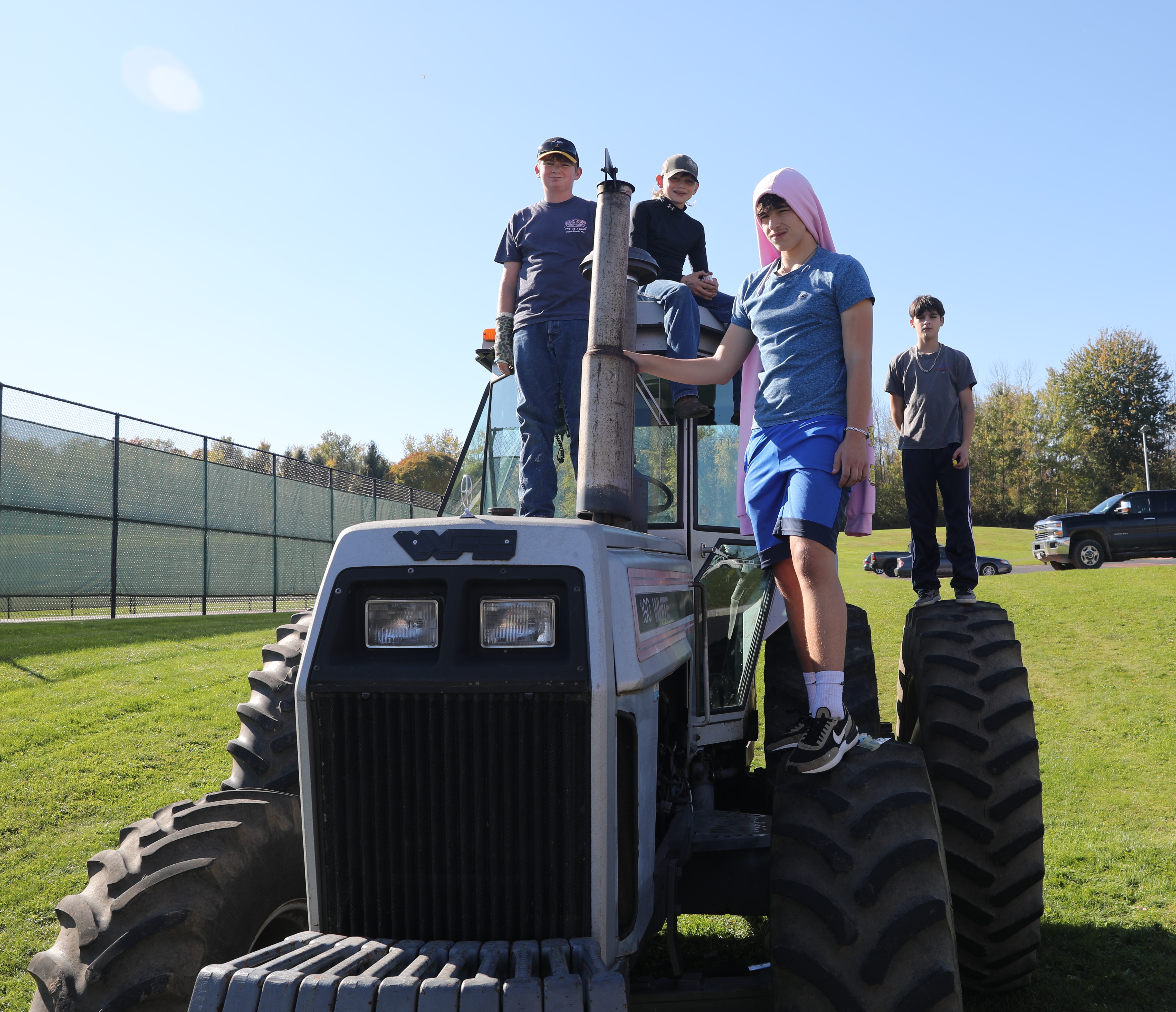 Students stand on a tractor