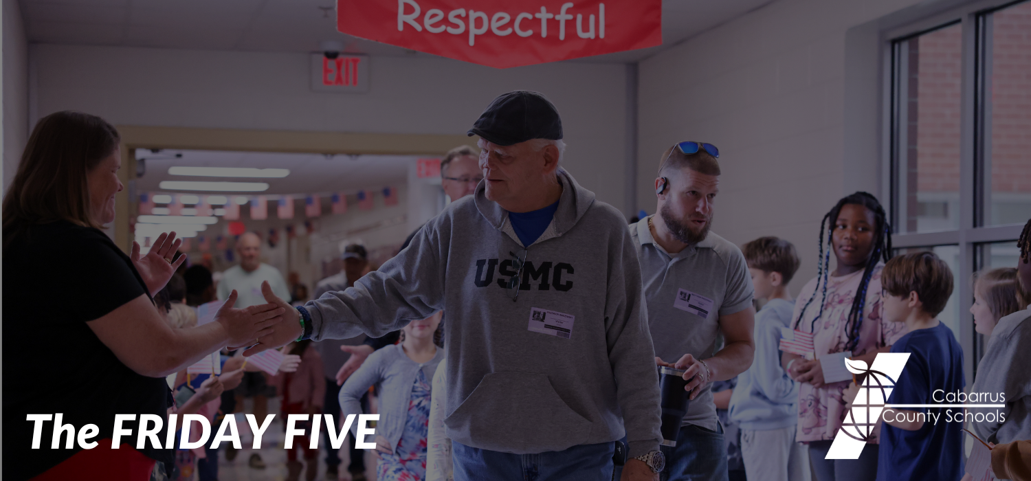 A veteran high-fives a staff member at A.T. Allen Elementary School.