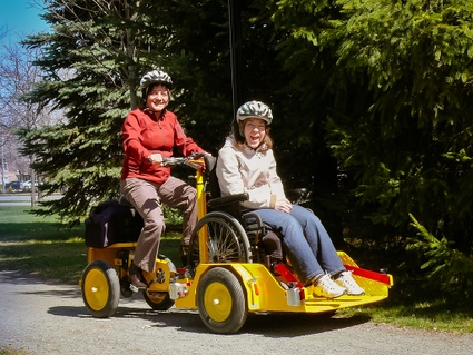 Vélo adapté aux personnes à mobilité réduite, sur la piste cyclable. Ici, le vélo permet d'accueillir un fauteuil roulant.