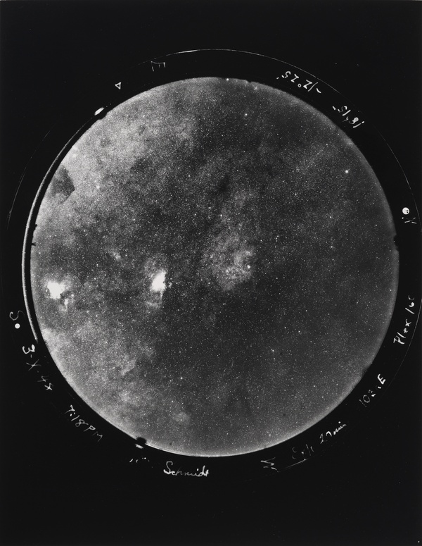 A black-and-white photograph with a circle of stars in the center with letters and numbers printed around the edge.