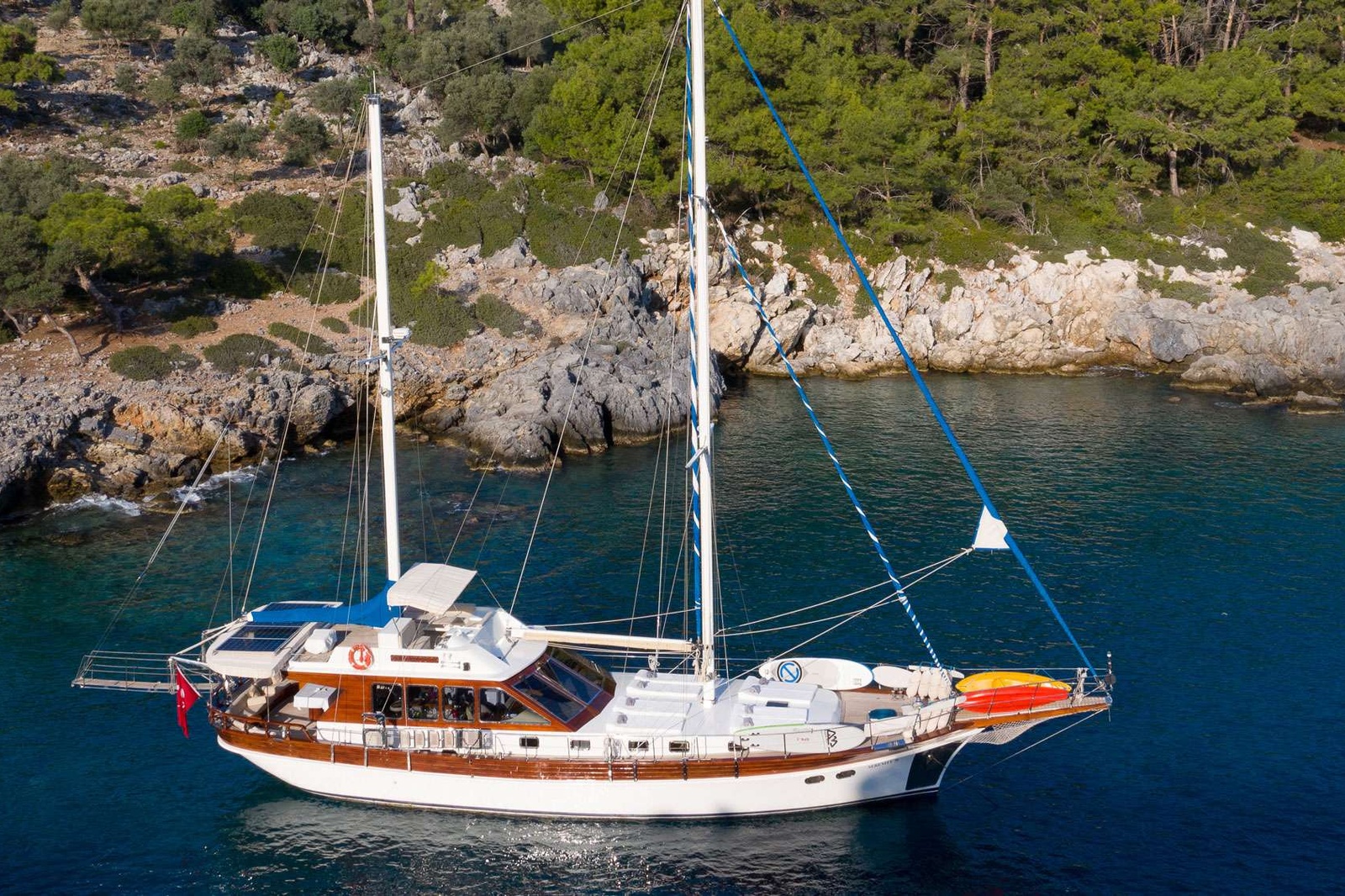 In current times when the industry is concentrating more and more on larger yachts, Serenity 70 is one of the few motor sailers that is available for charter in the East Med which is modest in size and budget without compromising on luxury and comfort. She has a very cosy honeymooner master cabin with a white interior and four portholes that flood in reflections from the sea. The remaining two double cabins are smaller in size and ideal for children or younger adults, though throughout her charter history this vessel has successfully accommodated six adults during many charters. Taking into consideration that guests will spend almost all their time outdoors, the limited space of the two double cabins is over shadowed by the comfortable aft dining area, inviting flybridge, ideal forward sun tanning area and the variety of amenities and water toys that you would normally only find aboard much larger vessels. The salon is very functional and includes a traditionally designed bar area with high seats facing panoramic views of the outside that is just perfect for enjoying an evening drink with friends and crew.