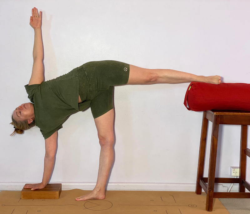 Extended Half Moon Pose with yoga block and bolster