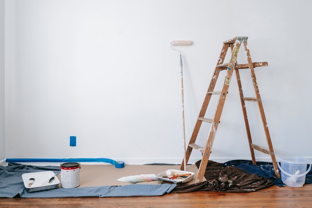 Remodeling vs Renovating A House: A Ladder, Painting Tools, and a White Wall