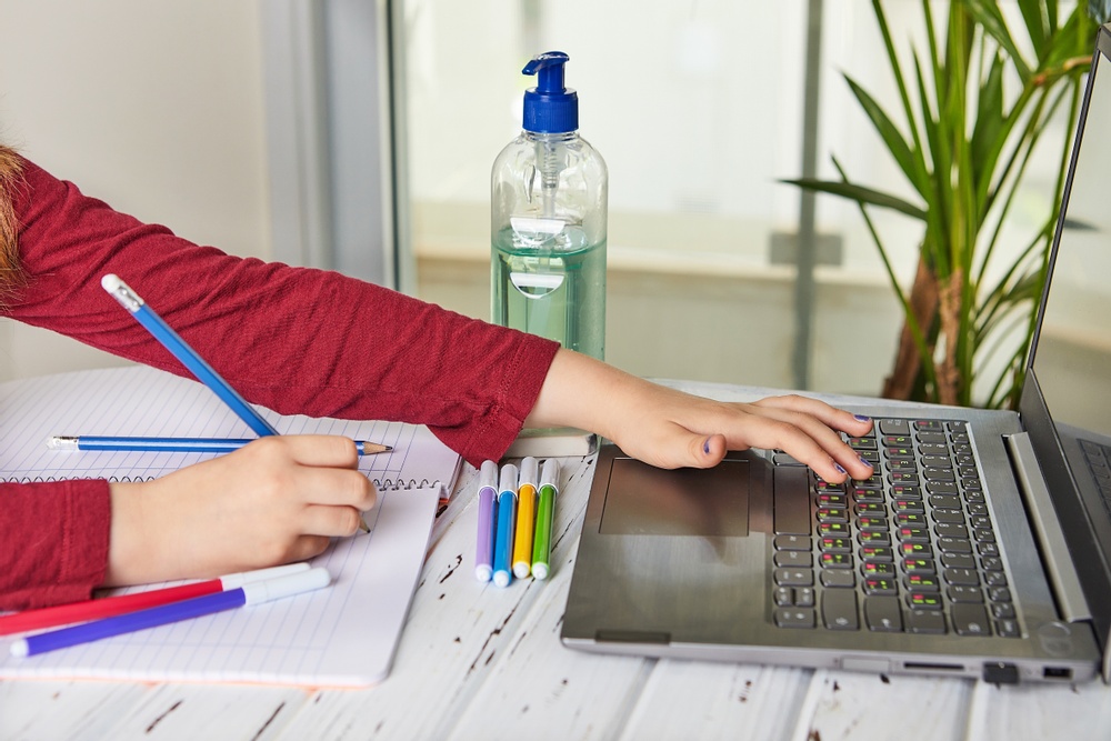 Ett barn sitter vid en dator och tar del av distansundervisning. 