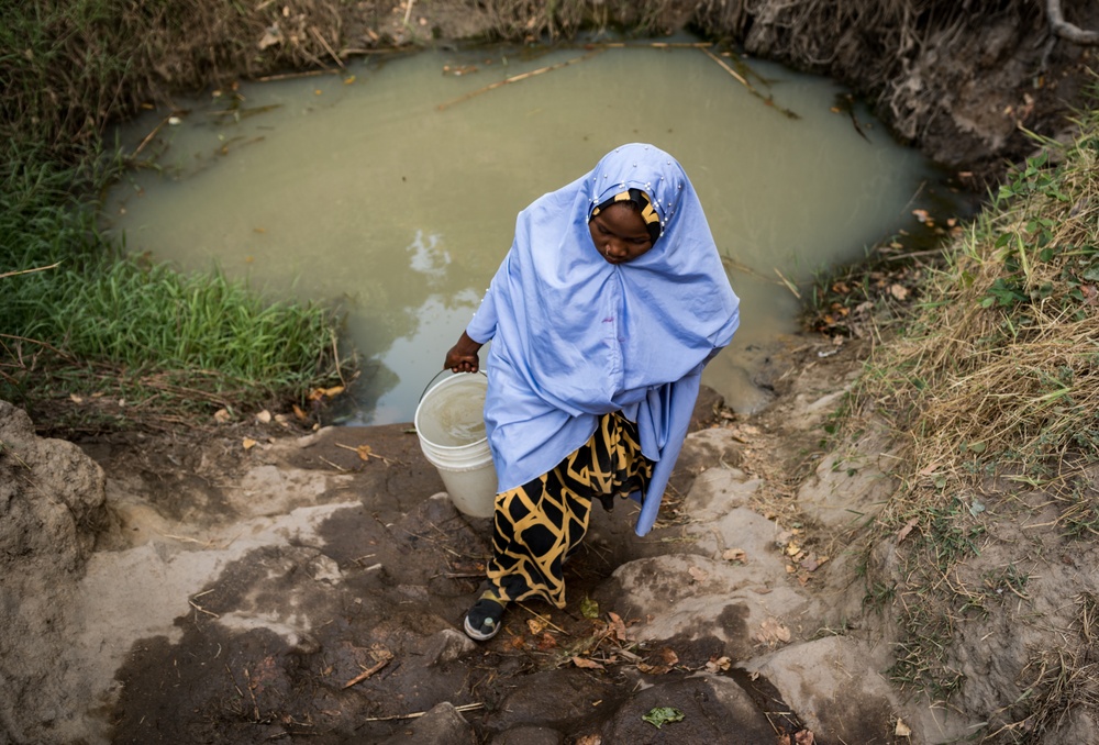 Foto: WaterAid/ Etinosa Yvonne
Karimatu, 17,  på hemväg efter att ha hämtat  vatten från dammen i Kwaja village, Adamawa, Nigeria. February 2021.