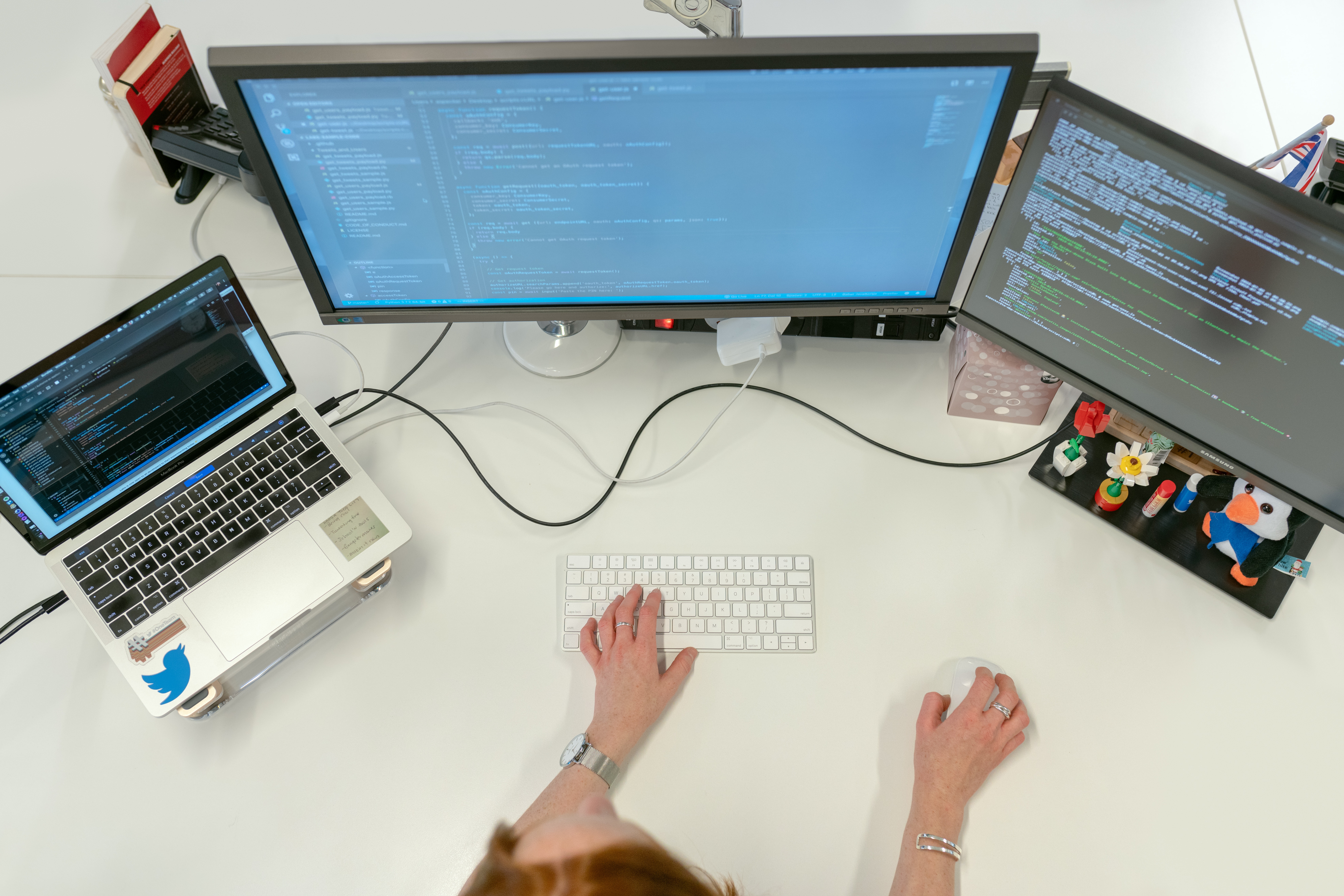 software engineer working on code from three monitors