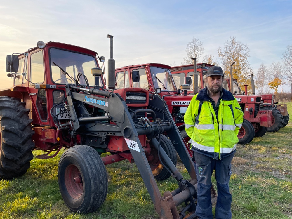 Volvo BM-samlaren Tomas framför några av sina kära veterantraktorer.