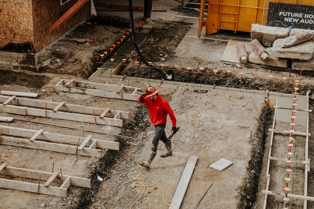 a man in red hoodie on a construction site