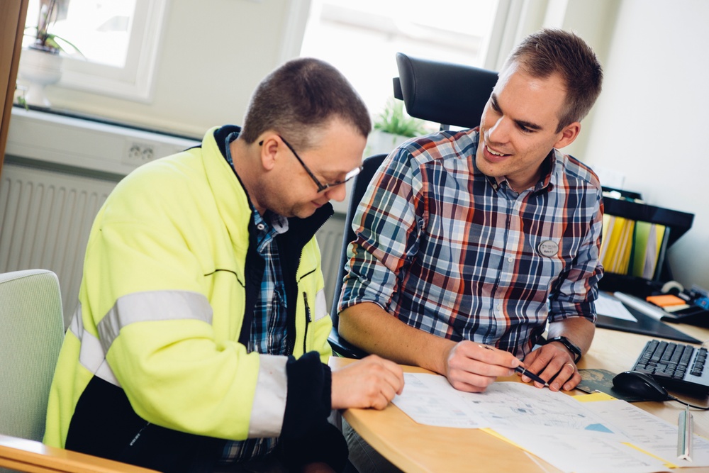 Bygglovshansläggare hjälper en man med sin anmälan eller ansökan.