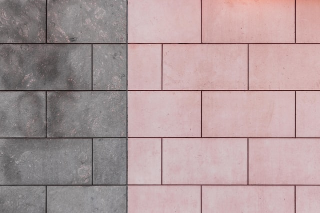 Different colored bathroom tile over concrete.