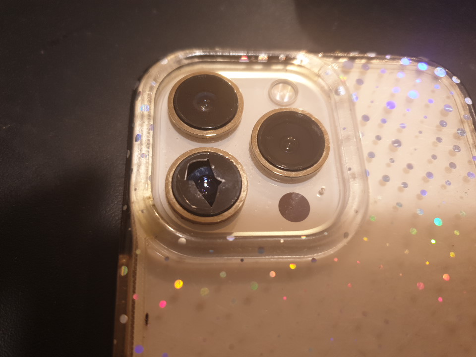 Damaged iPhone 13 Pro Max camera lens shown; replacement needed for clearer photos.