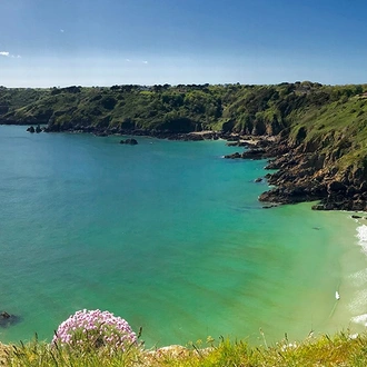 Isolated beach by the coastal cliffs of Guernsey island.