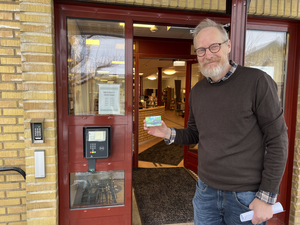 Gunnar Källström, biblioteksansvarig, visar upp det passerkort och den kortläsare som nu finns vid entrén till biblioteket i Nossebro. Dessa möjliggör inpassering i lokalerna även efter det att personalen gått hem för dagen.