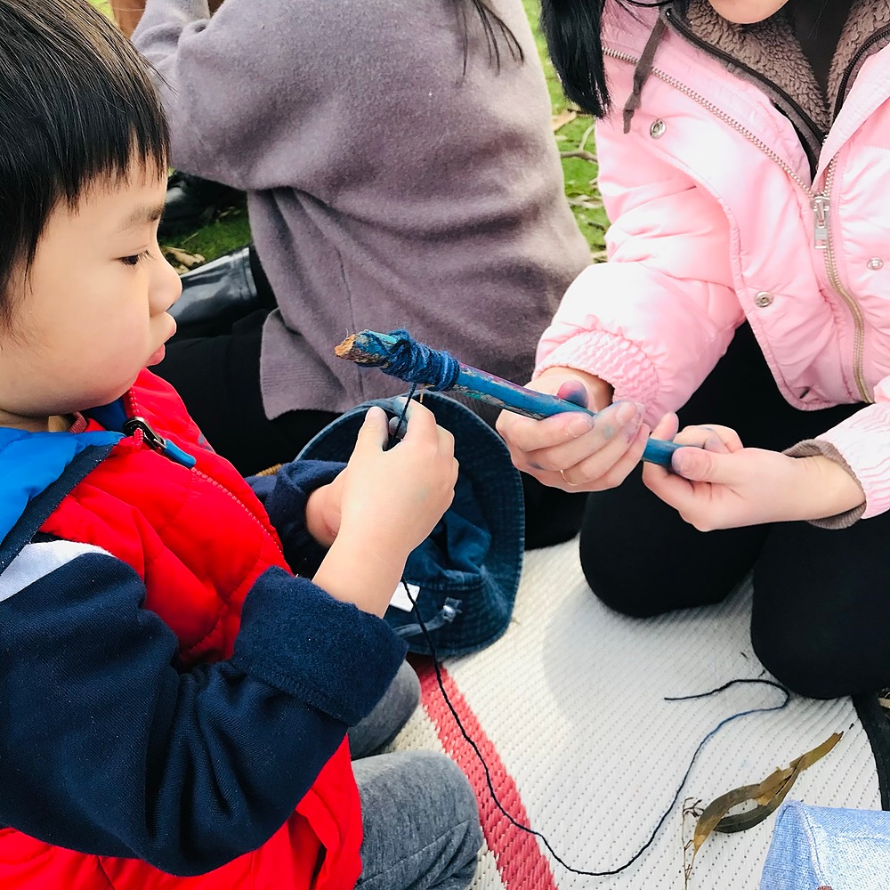 Child wrapping wool on a stick