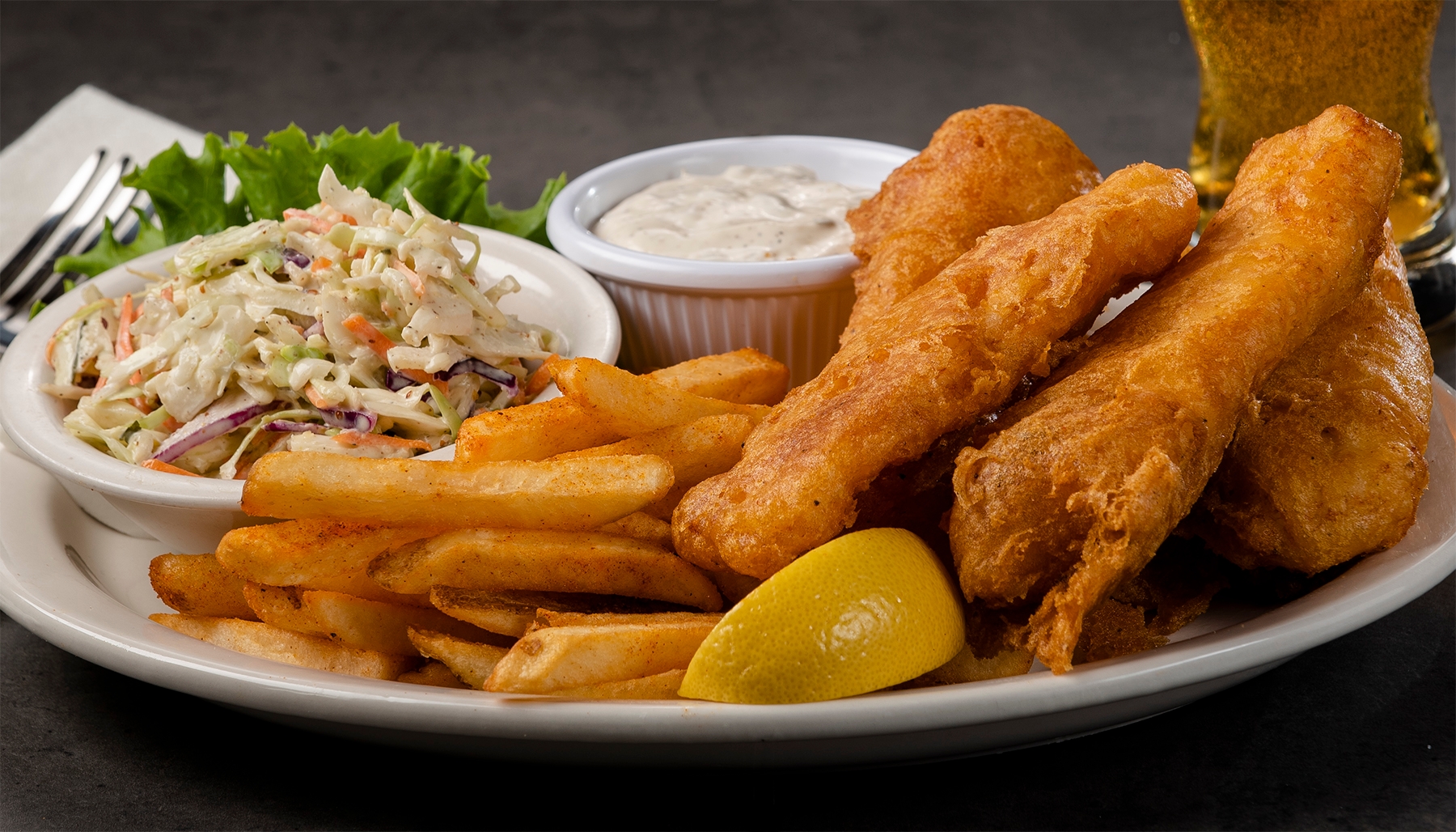 Wild caught North Atlantic cod fillets, beer battered and fried crispy, with tartar sauce, cole slaw and seasoned fries. 1040 cal.