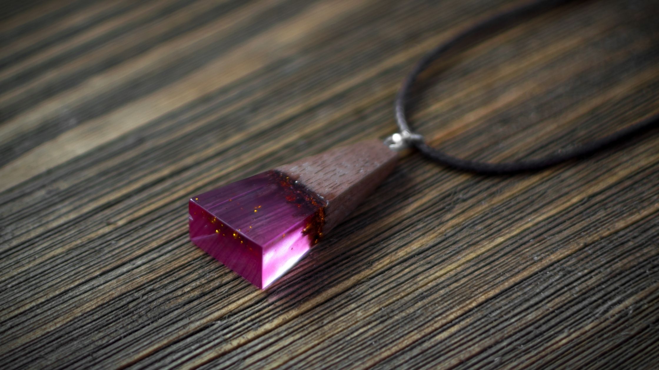 jewel on a necklace made of purple epoxy resin and wood