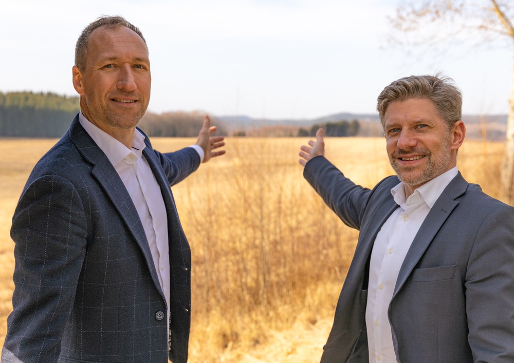 Jonas Engen och Daniel Filipsson pekar ut över fältet där Lindex lager ska byggas. 