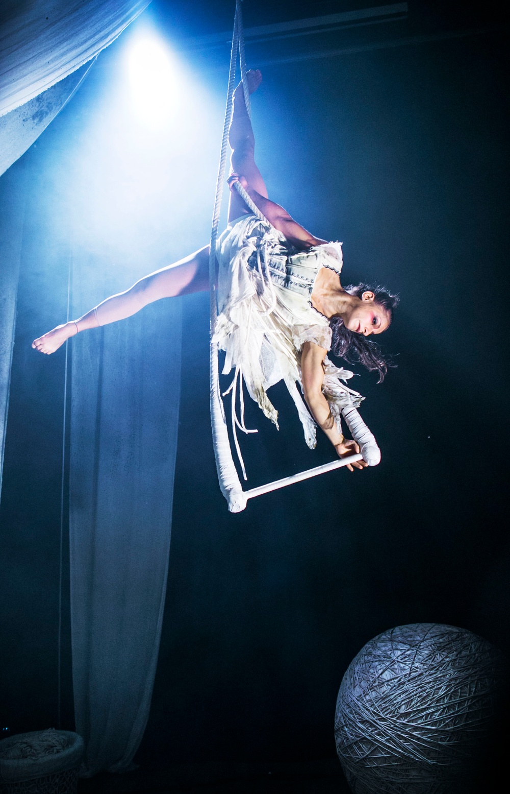Cirkusartist hänger i ett nät uppe i luften.