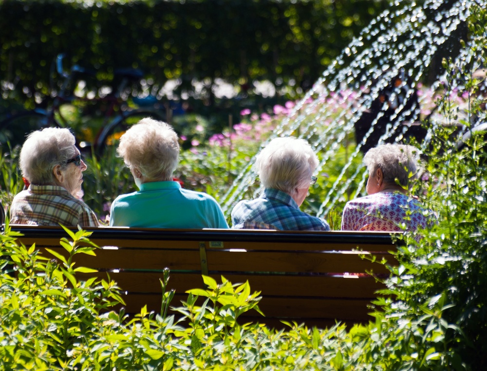 Bild på fyra pensionärer som sitter på en parkbänk.