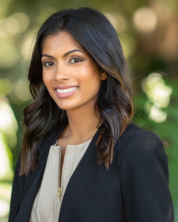 This is an image of Prabha Nandagopal, she is wearing a a black jacket and grey top