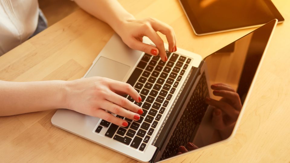 Women typing on laptop to access UAE data protection law 