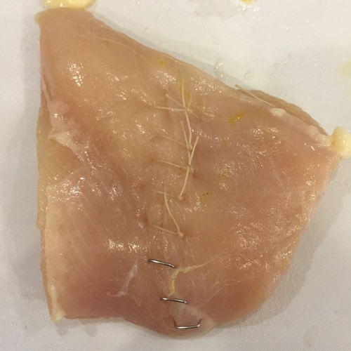 Practicing suturing a chicken breast.