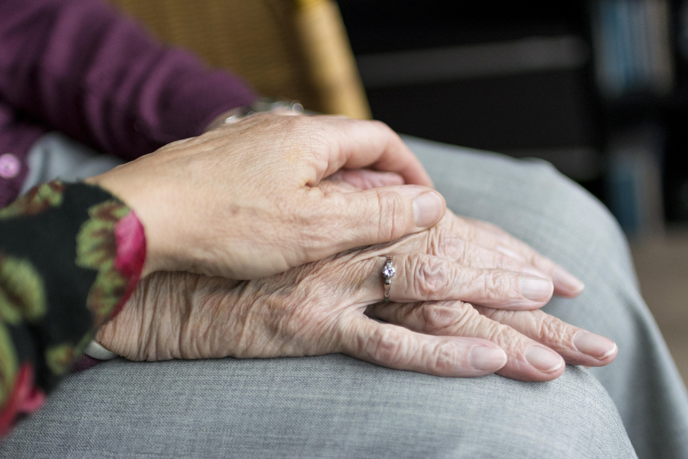 En person lägger sin hand på en medmänniska