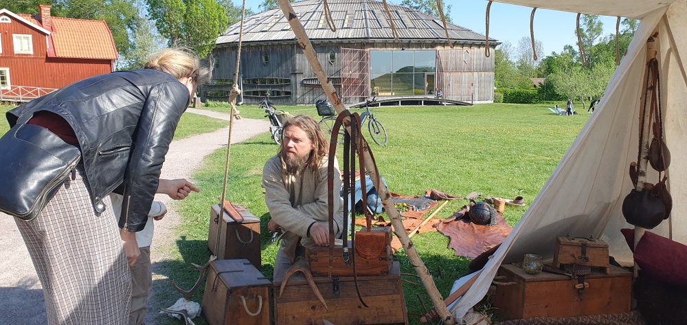 Vikingasällskapet Svíar visar upp hantverk för besökare framför Gamla Uppsala museum.