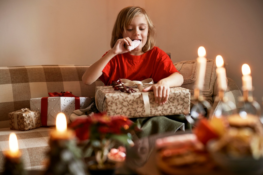 Barn som äter godis och öppnar julklappar.