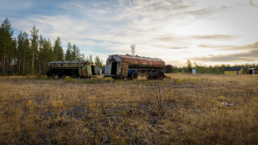 Bilden visar gamla tankbilar på ett brandövningsfält.