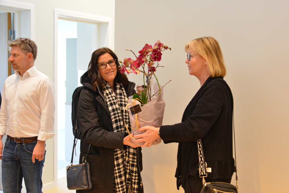 Förvaltningschef Anita Hedström lämnar över en blomma till Caroline Ålleving som blir enhetschef på det nya boendet. 