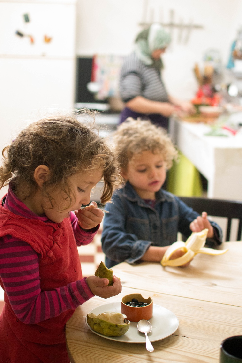 Tå barn sitter och äter mat