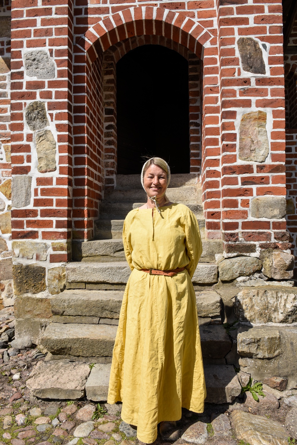 Volontären Marianne Mårtensson framför Dekanhuset på Kulturen i Lund. Foto: Viveca Ohlsson, Kulturen. 