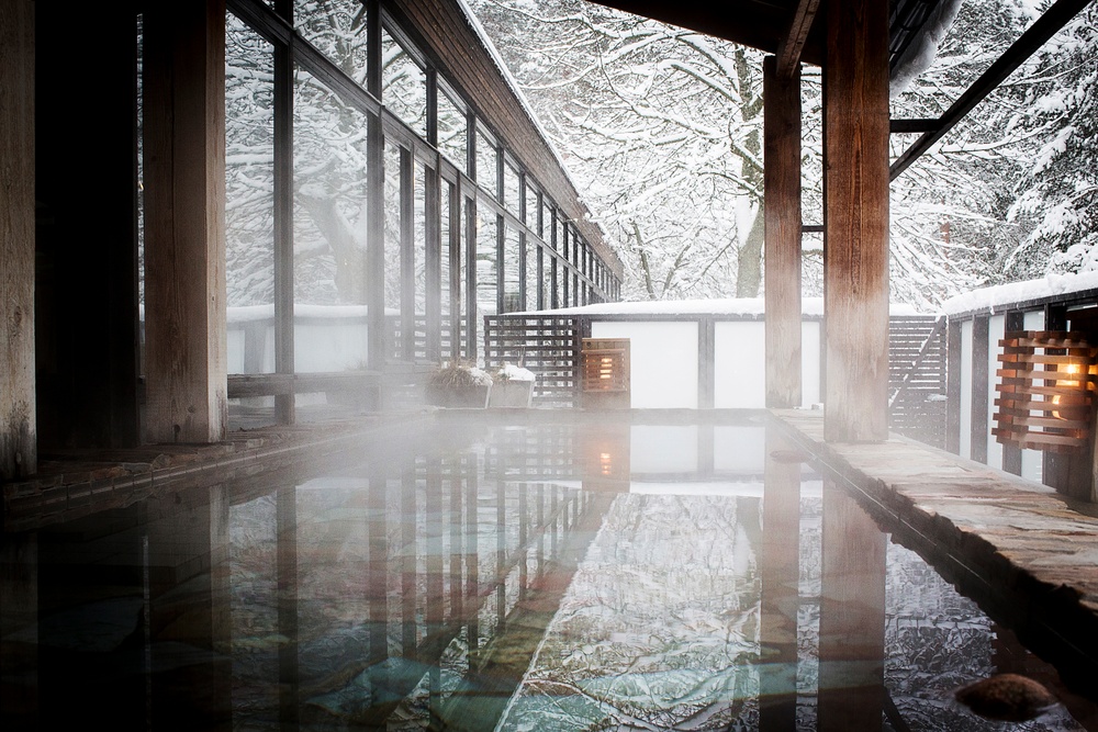 Our hot water terrace baths with the surrounding pine trees covered in snow during the Swedish winter months.