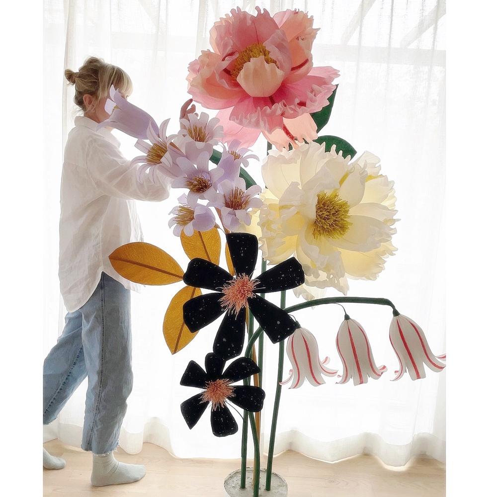 Hanna Nyman med sina två meter höga blommor gjorda i papper.
