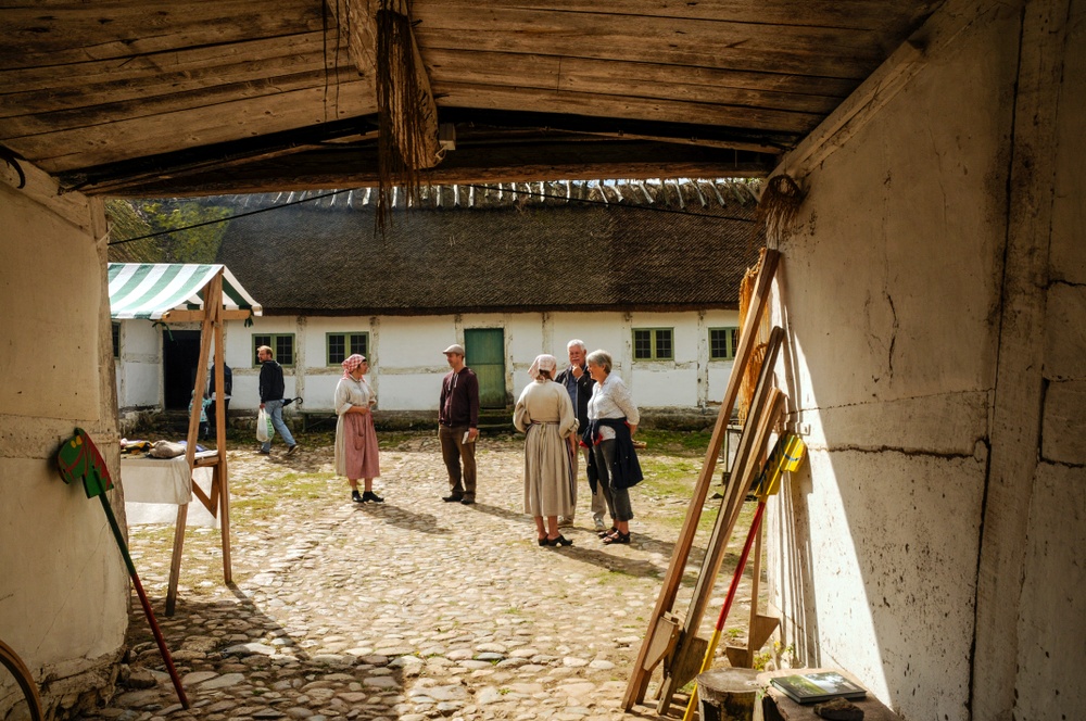 Värdar samtalar med besökare på Gamlegårds innergård på Kulturens Östarp. Foto: Viveca Ohlsson/Kulturen
