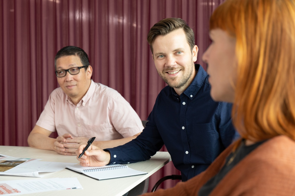 Employer branding-bild från Bjerking visar medarbetare i möte där en person ler och ser in i kameran