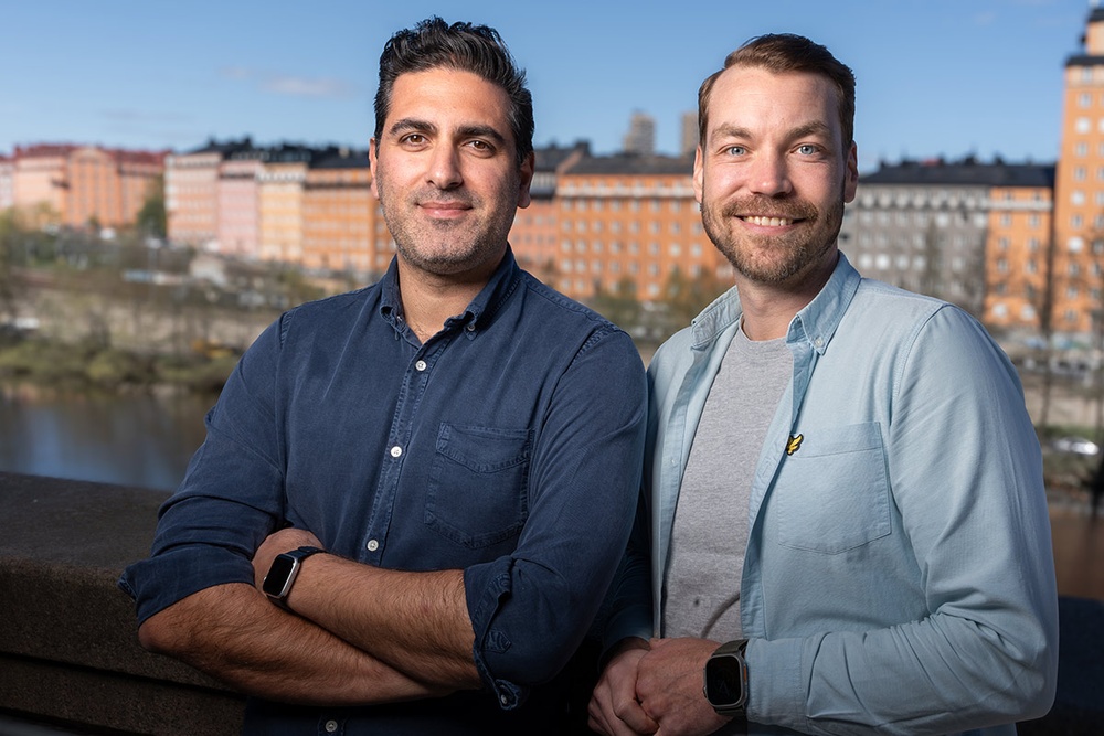 Entreprenörerna Aref Abedi och Simon Werner-Zankl står tillsammans på en balkong.