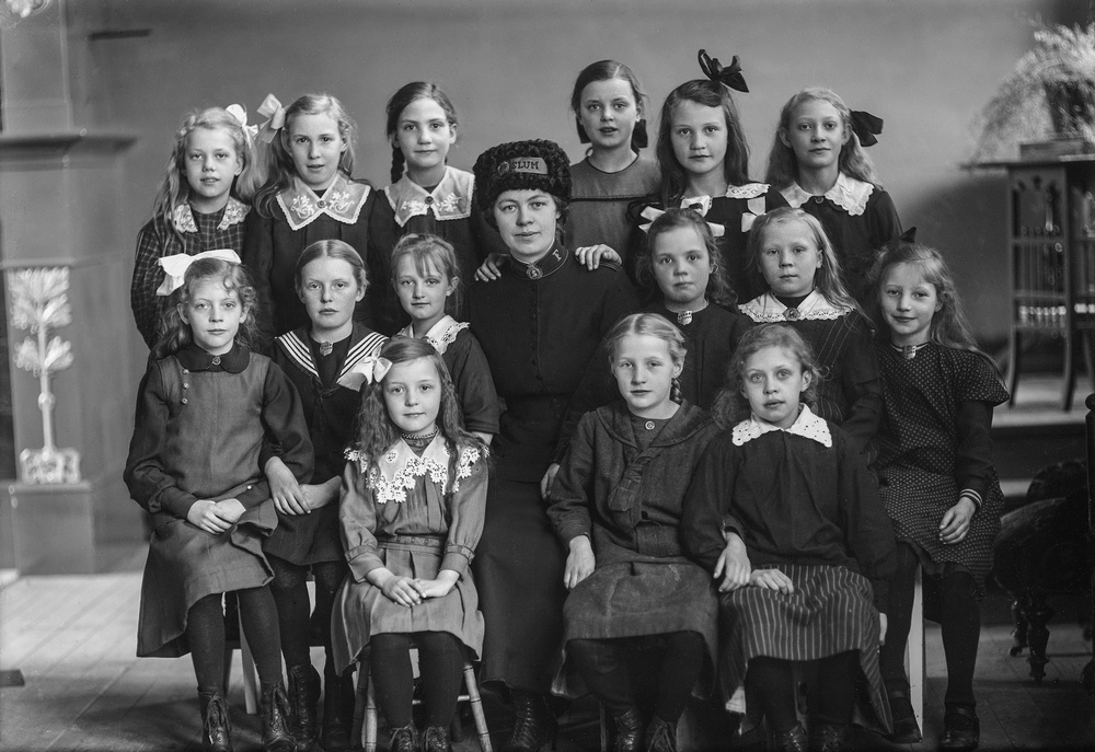 Kvinna i Frälsningsarméns uniform och flickor från barnkåren. Foto:  Ida Ekelund, ur Kulturens samlingar. 