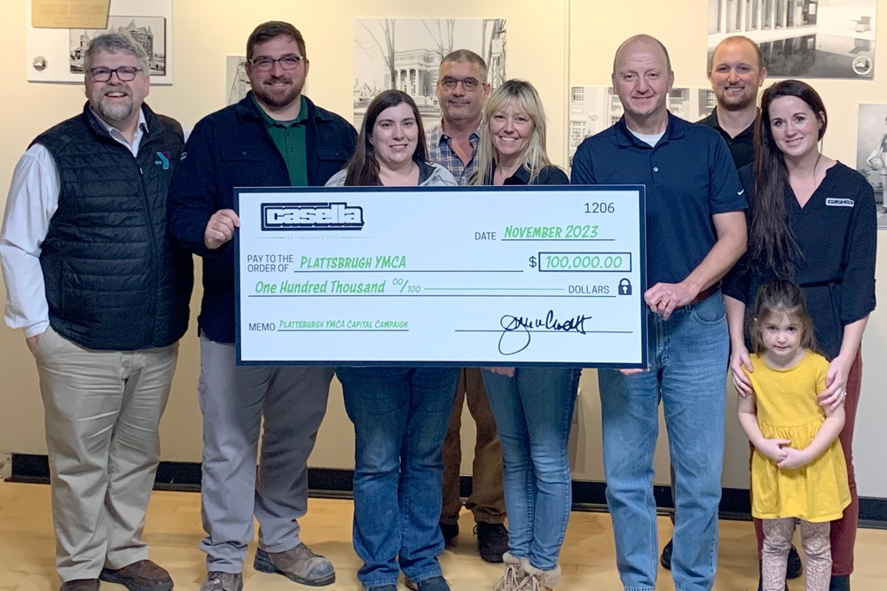 Members of the local Casella hauling division present a check for $100,000 to the YMCA. in Plattsburgh, NY