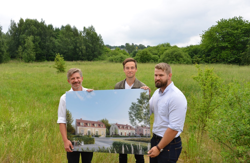 Daniel Filipsson, Jesper Sjögren och Simon Waern håller upp en skylt med en skiss över de nya småhusen.