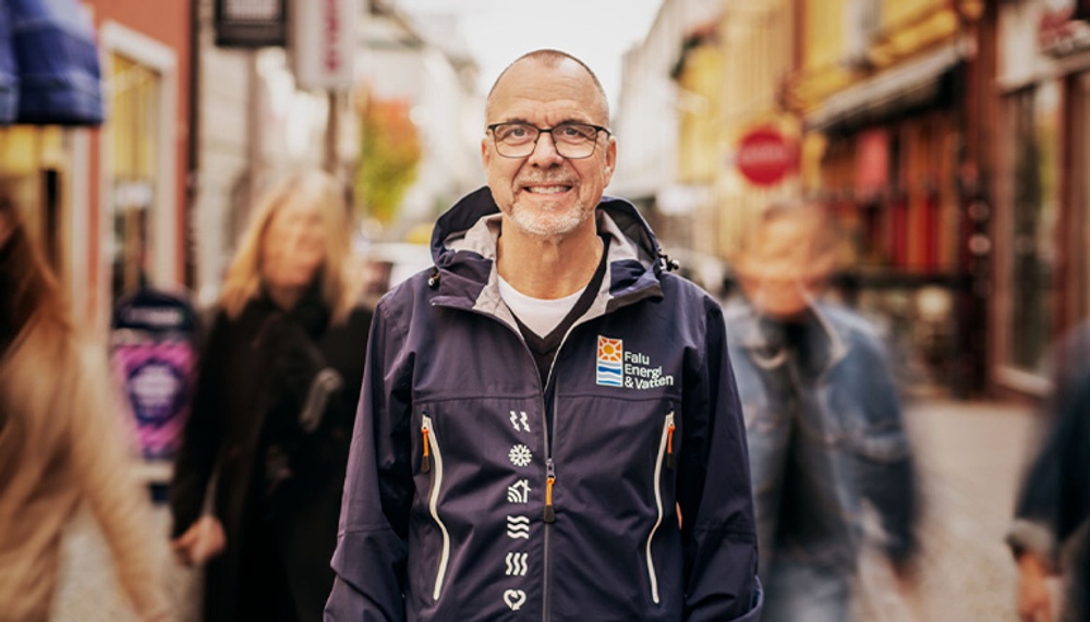 Man står på Holmgatan och människor passerar förbi. 