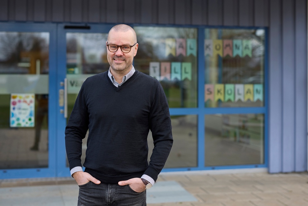 Andre Essebro står framför en skolentré i Vara kommun.