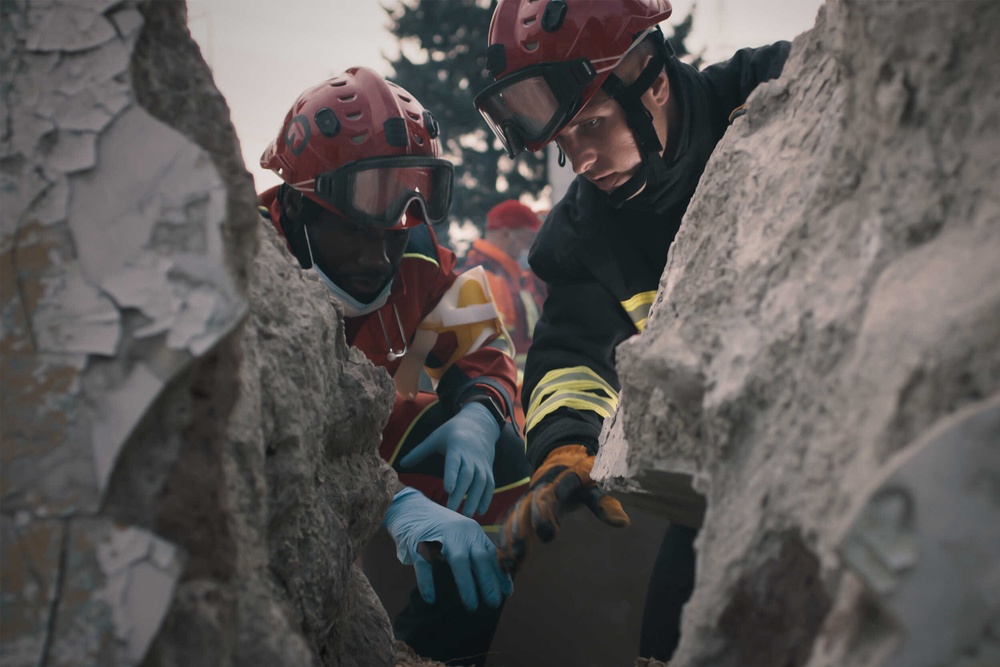 rescue workers looking through debris for survivors after an earthquake