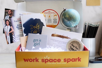 A Work Space Spark subscription box with a few small notebooks, a journal, and a ring toss game.